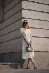 a lady wears a white round neck knit top and a maxi skirt